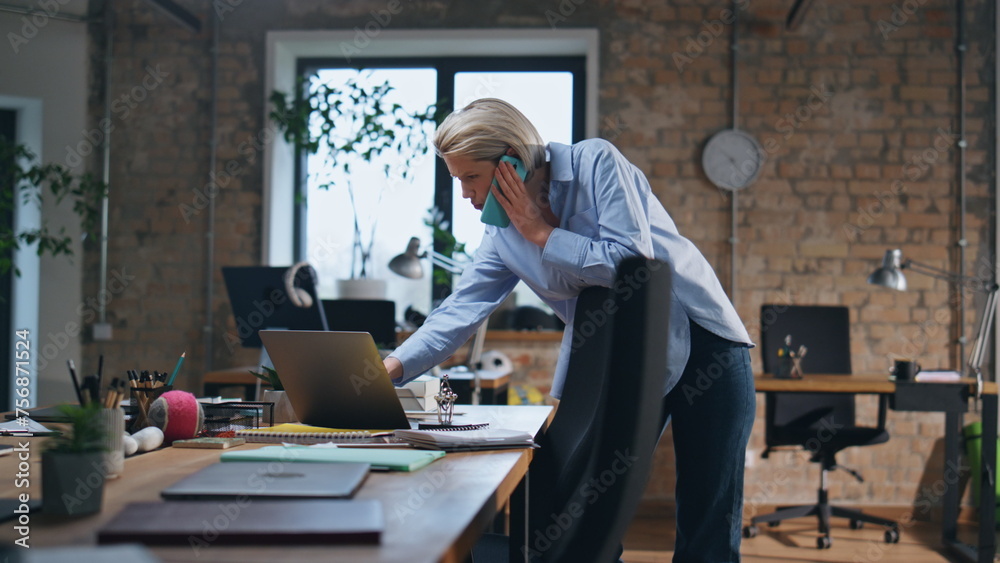 Fototapeta premium Businesswoman have phone negotiation in empty office. Smart woman looking laptop