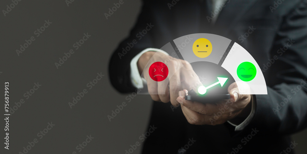 © Pheniti - A man is holding a cell phone and pointing to a happy face
