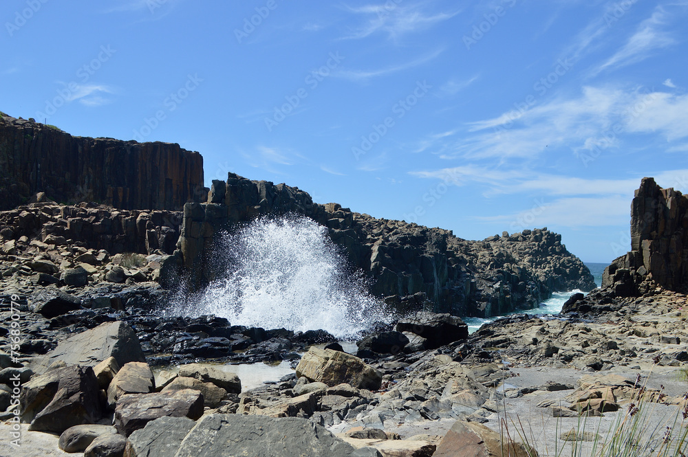 Waves crash into rock formations at Bombo on the South Coast of New South Wales, Australia.