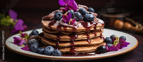 A stack of fluffy pancakes topped with blueberries and drizzled with decadent chocolate sauce on a plate  a delightful dessert perfect for sharing at any event