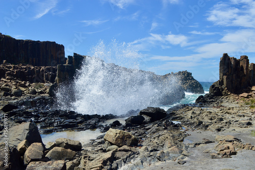 Waves crash into rock formations at Bombo on the South Coast of New South Wales, Australia.