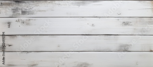 A close up of a rectangular white hardwood plank flooring with a grey blurred background, showcasing a parallel pattern of tints and shades from the wood stain