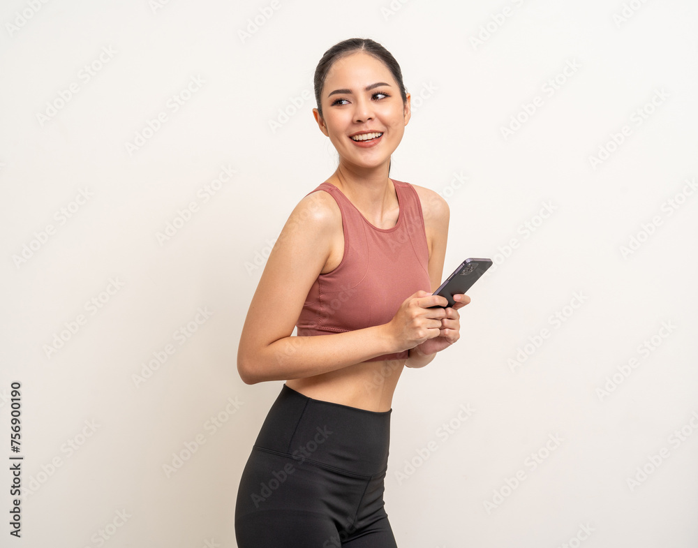 Naklejka premium Young beautiful asian woman with sportswear using smartphone on isolated white background. Attractive Portrait latin sporty woman standing pose holding cell phone exercise workout in studio.