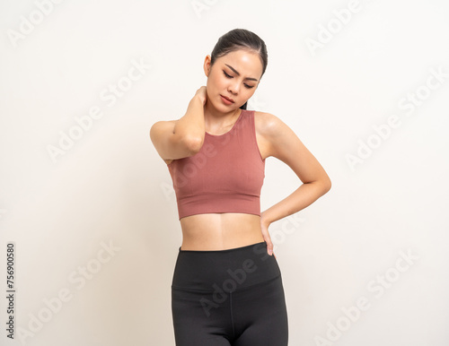 Young sporty asian woman has inflamed neck and backache because she is workout exercise too much. Accident suffering while training workout. She massage to soothe and relax on isolated background. © Chanakon