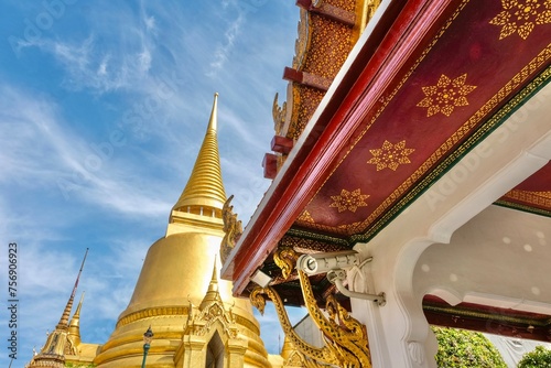 Phra Si Rattana Chedi, a gold bell-shaped stupa, framed by the decorative underside of a pavilion at the Wat Phra Kaew (Temple of the Emerald Buddha) - Grand Palace, Phra Nakhon, Bangkok, Thailand  photo