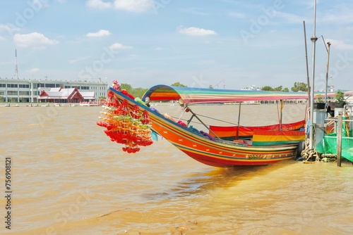 Canvas Print A colourful Thai longtail boat with flower garlands docked on the banks of the C