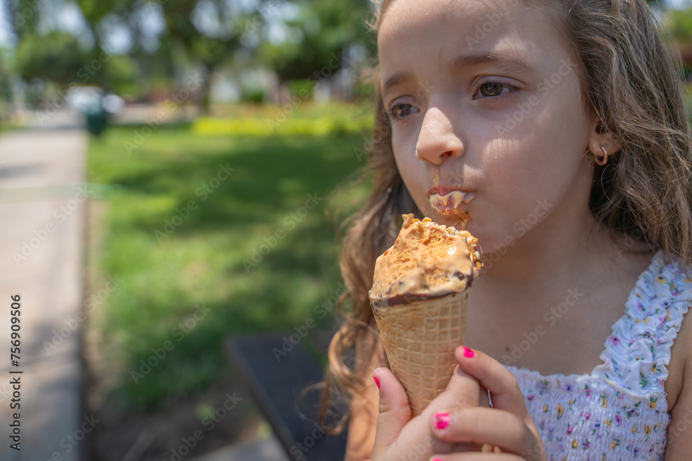 Cute girl licking an ice cream in a park Cute girl licking an ice cream in a park