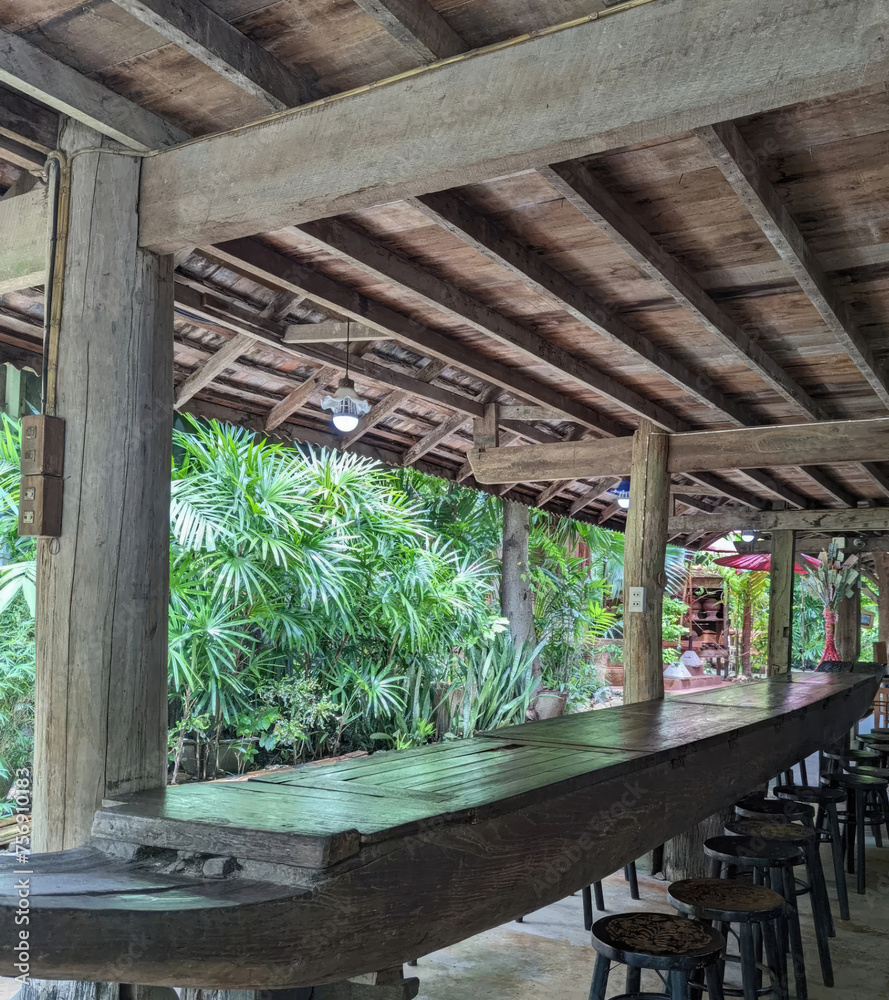 Wooden table and chairs in the restaurant with natural background, Thailand.