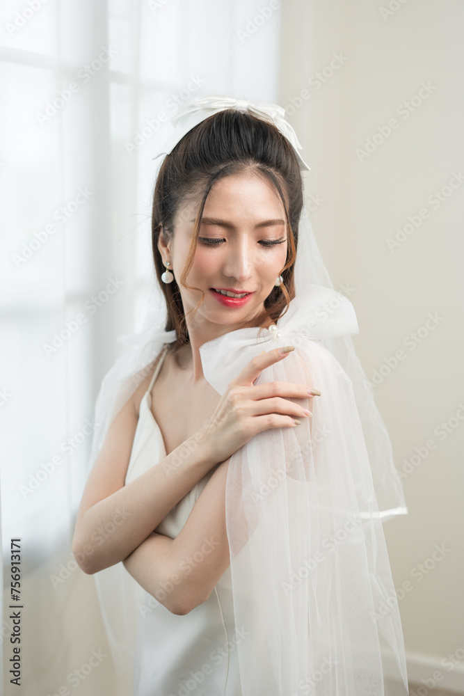 Beautiful asian bride with fashion wedding hairstyle and makeup. Portrait of young gorgeous bride wedding studio shot in white room.