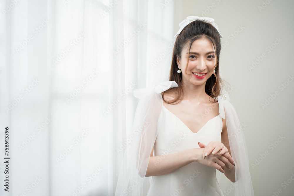 Beautiful asian bride with fashion wedding hairstyle and makeup. Portrait of young gorgeous bride wedding studio shot in white room. Beautiful asian bride with fashion wedding hairstyle and makeup. Portrait of young gorgeous bride wedding studio shot in white room.