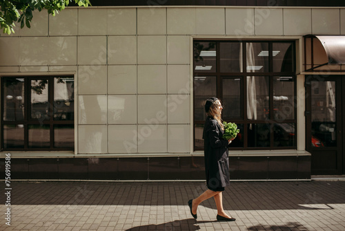 Woman Walking Down Street With Green Bag