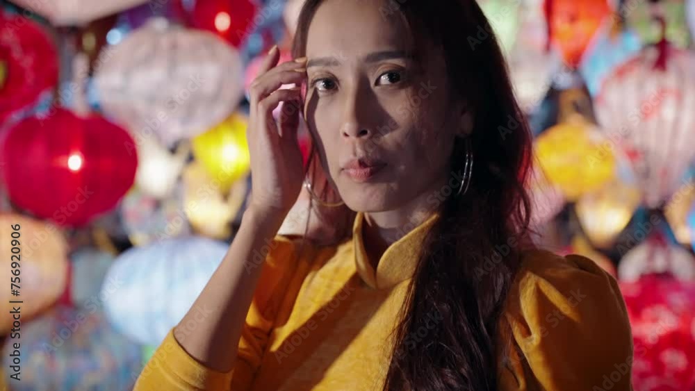 Woman in yellow Ao Dai admires colorful lanterns in Hoi An at night Woman in yellow Ao Dai admires colorful lanterns in Hoi An at night