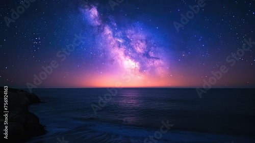 Milky Way galaxy over the ocean with rocky coastline in the foreground © JanNiklas