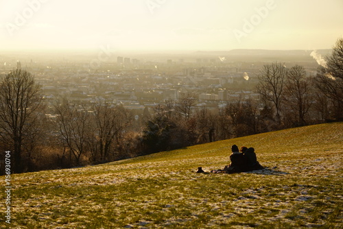 Couple sitting watching the sunset over the city view in Freiburg im Breisgau, Germany © Thanha