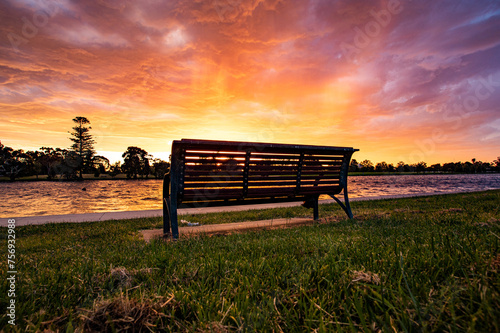 A lone chair under the rosy clouds and romantic sky in the sunset near the Albert Lake in Melbourne photo