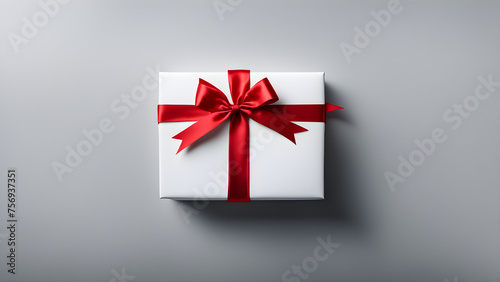 Gift tied with red ribbon on solid color background, holiday gift, space for text 