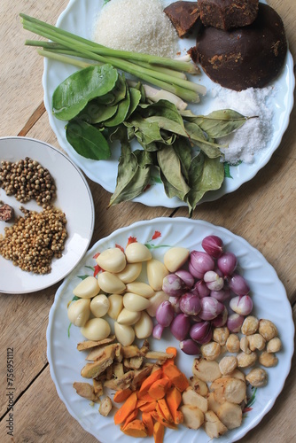 Various kinds of Indonesian cooking spices in plates on the table photo