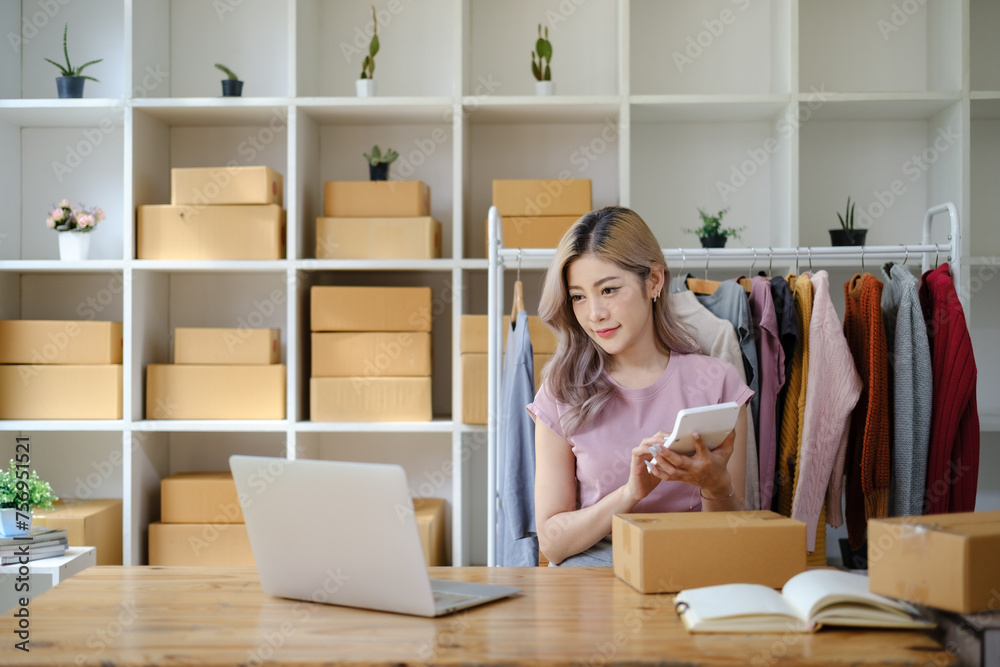 Online shopping concept, Female entrepreneur calculate the order and writes address on parcel boxes. Online shopping concept, Female entrepreneur calculate the order and writes address on parcel boxes.