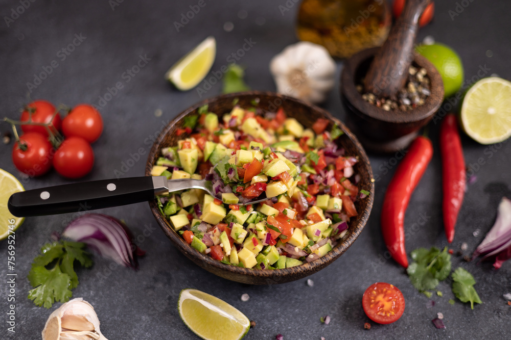 traditional salsa dip snack in wooden bowl on a table with ingredients traditional salsa dip snack in wooden bowl on a table with ingredients