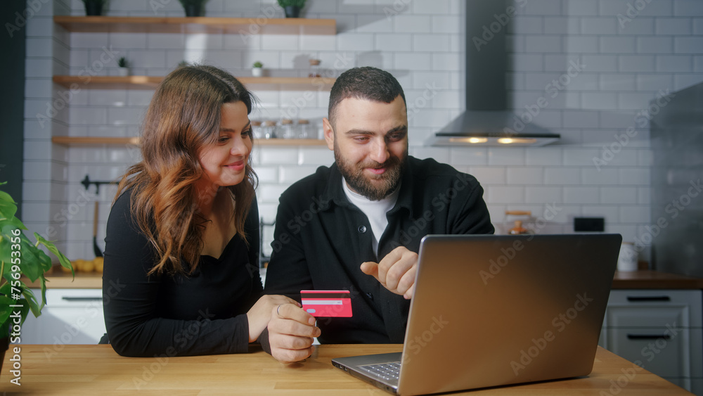 Young couple sit in the kitchen picking goods to buy man enter credit card number on laptop for shopping online, makes secure easy distant electronic payment
Young couple sit in the kitchen picking goods to buy man enter credit card number on laptop for shopping online, makes secure easy distant electronic payment