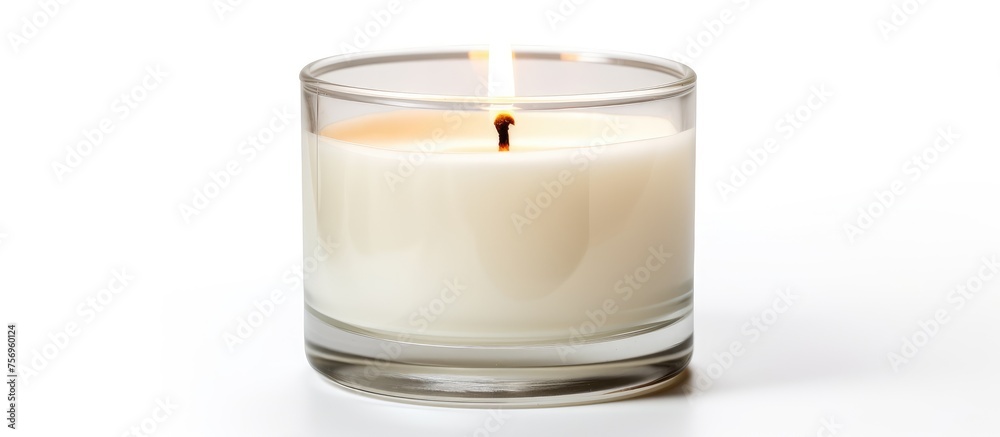 A liquid candle in a highball glass sits on a white background. The glass is a type of drinkware used for alcoholic beverages, creating a relaxing ambiance A liquid candle in a highball glass sits on a white background. The glass is a type of drinkware used for alcoholic beverages, creating a relaxing ambiance