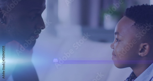 Image of lights over happy african american son having fun with father on sofa