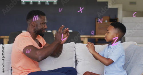 Image of letters over happy african american father and son playing finger games