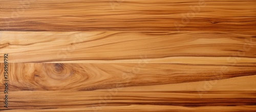 A closeup shot of a brown hardwood plank flooring with a beautiful grain pattern  showcasing the amber tones of the wood stain and varnish