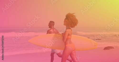Image of happy couple at beach on sunny day carrying surfboards over colourful light