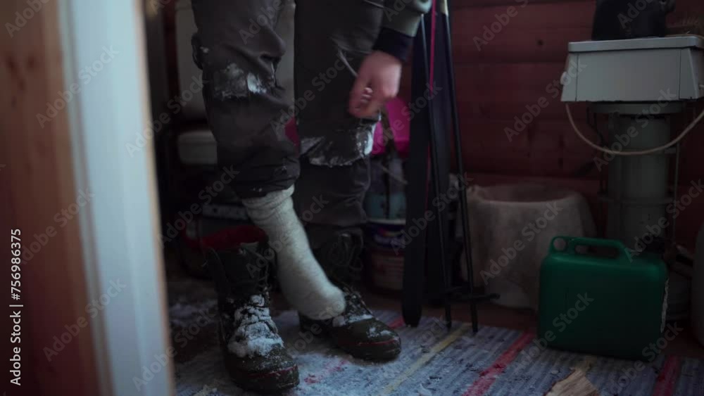A Man is Removing His Shoes, Dusted with Snow, During the Winter Season in Bessaker, Trondelag County, Norway - Close Up A Man is Removing His Shoes, Dusted with Snow, During the Winter Season in Bessaker, Trondelag County, Norway - Close Up