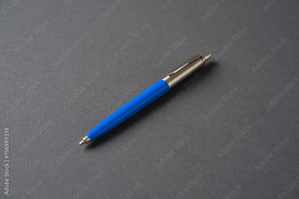 Blue plastic and metal ballpoint pen on dark gray background Blue plastic and metal ballpoint pen on dark gray background