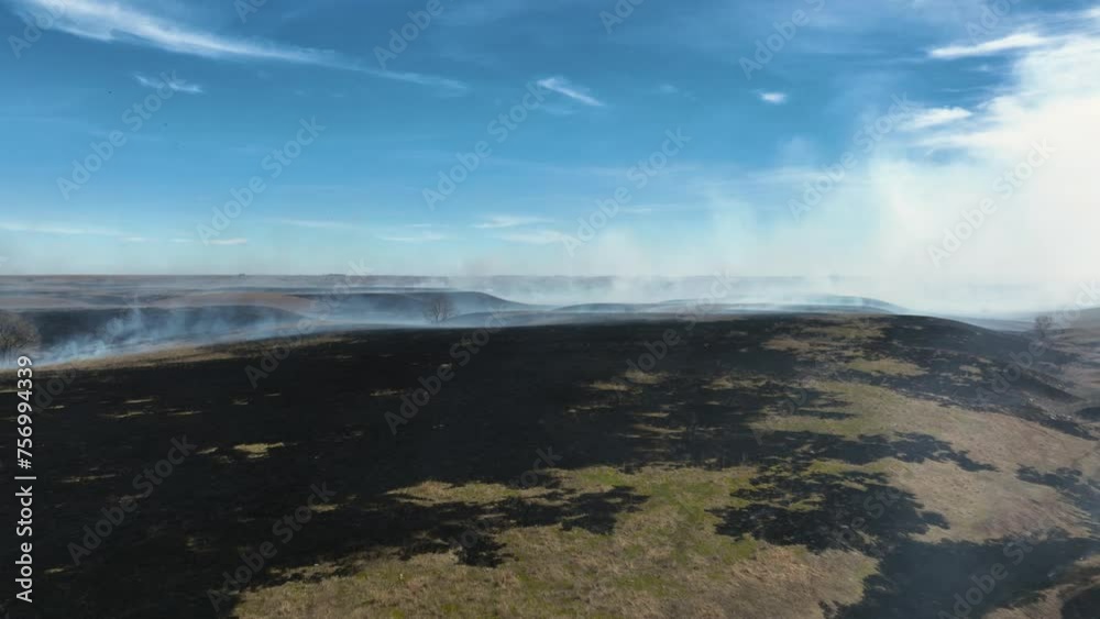 Flying over line of fire to reveal completely burnt prairie in the flint hills of Kansas after controlled burn. Drone Shot Flying over line of fire to reveal completely burnt prairie in the flint hills of Kansas after controlled burn. Drone Shot