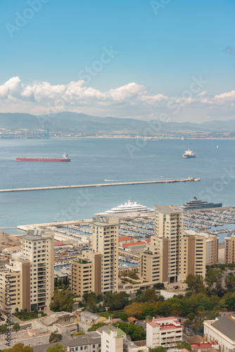 Aerial view of the city of Gribraltar with its tall buildings, ships in the sea and the mountains in the background. photo
