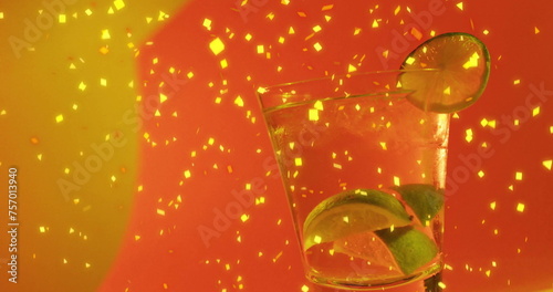 Image of confetti falling and cocktail on red background