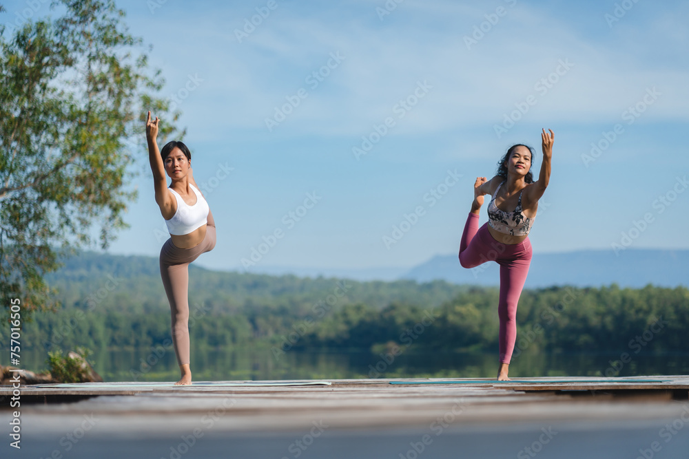 Beautiful attractive Asian woman practice fitness yoga pose on the pool above the Mountain peak in front of nature lake views, Feel so comfortable lifestyle and relax exercise in holiday morning