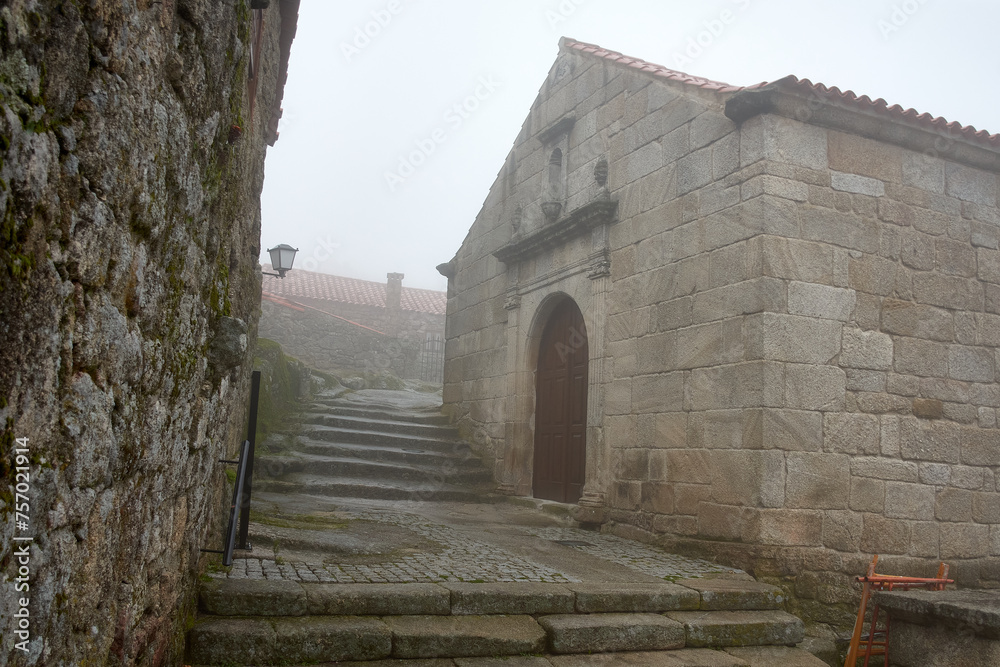 Narrow streets among the fog of the historic village of Sortelha in Portugal