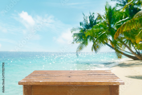 Fototapeta Naklejka Na Ścianę i Meble -  Empty wooden planks table for product placement on blur tropical palm beach background