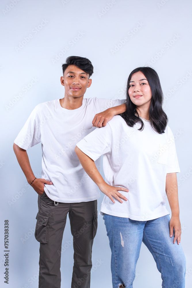 Asian man and woman couple wearing white t-shirt for mockup on grey background. Asian man and woman couple wearing white t-shirt for mockup on grey background.