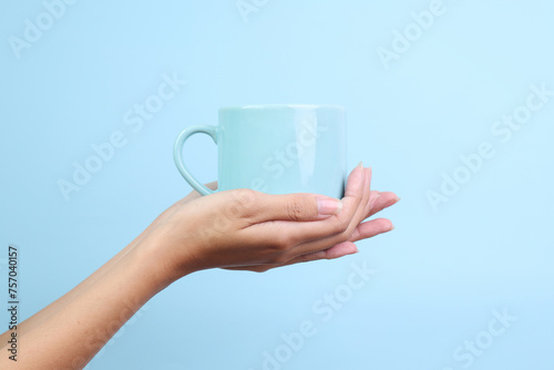 Hands Holding Ceramic Mug for Mockup Isolated on Blue Background