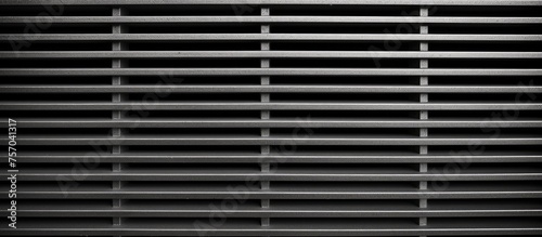A close up of a rectangle metal grille with symmetrical patterns on a black background, showcasing automotive exterior technology and lighting features