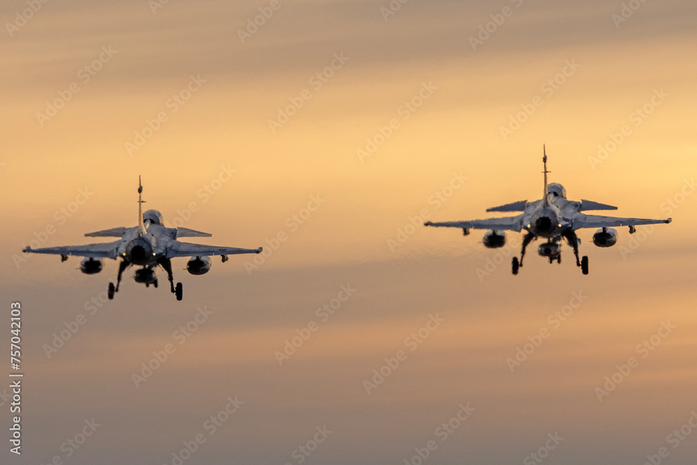 Aviones de combate aterrizando al anochecer