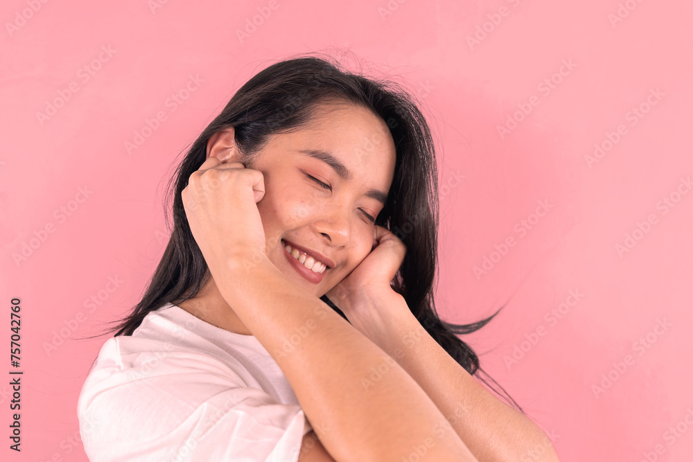 Attractive brunette Asian girl feeling happy and romantic, heart-shaped gesture, showing tender feelings, wearing a casual jumper, posing against a pink background. Attractive brunette Asian girl feeling happy and romantic, heart-shaped gesture, showing tender feelings, wearing a casual jumper, posing against a pink background.