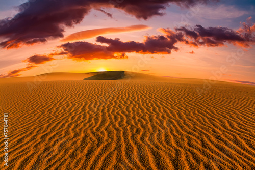 Dramatic sunset over the sand dunes in the desert. Namib desert.