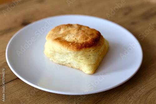 Scone on the white plate on the table.