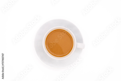 Creamy coffee on a white porcelain cup, isolated on white background with copy space. Top view or flat lay.
