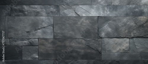 A close up of a grey rectangle tile wall with a symmetrical pattern. The monochrome photography emphasizes the tints and shades of the composite material used for this building material