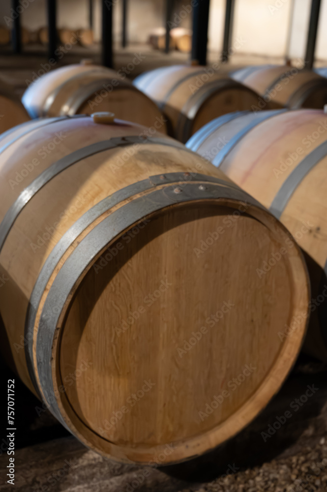 WIne celler with french oak barrels for aging of red wine made from Cabernet Sauvignon grape variety, Haut-Medoc vineyards in Bordeaux, left bank Gironde Estuary, Pauillac, France WIne celler with french oak barrels for aging of red wine made from Cabernet Sauvignon grape variety, Haut-Medoc vineyards in Bordeaux, left bank Gironde Estuary, Pauillac, France