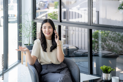 Successful businesswoman financier investors use smartphone to communicate remotely over the internet or video call to set challenging business goals and ready to achieve targets from work office