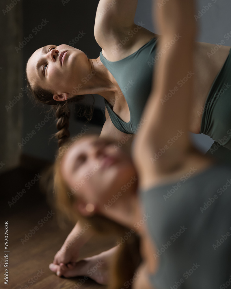 Women doing yoga. Standing Triangle Pose. utthita trikonasana asana. Concentrated face of yoga woman looking up. training in Pilates, stretching in gym. Exercises to stretch leg. Side view. Close-up. Women doing yoga. Standing Triangle Pose. utthita trikonasana asana. Concentrated face of yoga woman looking up. training in Pilates, stretching in gym. Exercises to stretch leg. Side view. Close-up.
