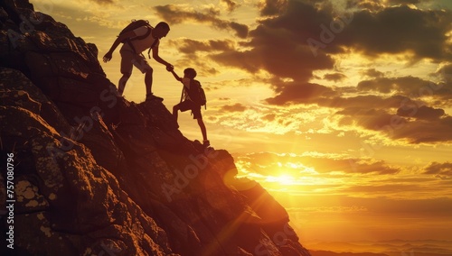 Silhouette of a man and a woman climbing a mountain at sunset